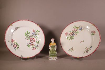 Deux assiettes et une petite figurine sont posées sur une table