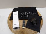 the contents of a chanel eau bag are on a wooden tray