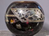 a black vase with a silver design on it
