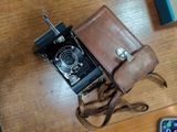 an old camera and a cell phone sitting on a table