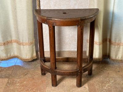 un petit tabouret en bois posé sur un sol carrelé, à côté d'un rideau