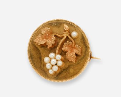 une image représentant une broche en or ornée de perles et de feuilles