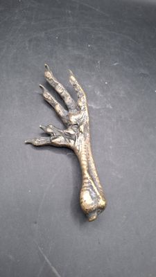une image représentant une main en métal posée sur une table