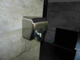 a stainless steel hand dryer on the wall in a bathroom