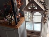 a birdhouse with a window on top of a cabinet