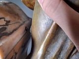 a hand that is holding a statue of a man