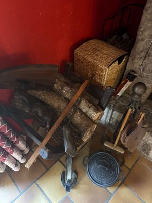 un tas de bois posé par terre à côté d'une cheminée