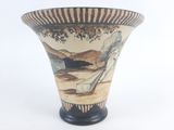 a vase with a painting on it sitting on a table