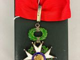 une petite médaille ornée d'un ruban rouge et d'une couronne