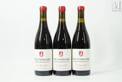 trois bouteilles de vin rouge posées l'une à côté de l'autre sur une surface blanche