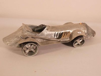 a silver toy car that is sitting on a table