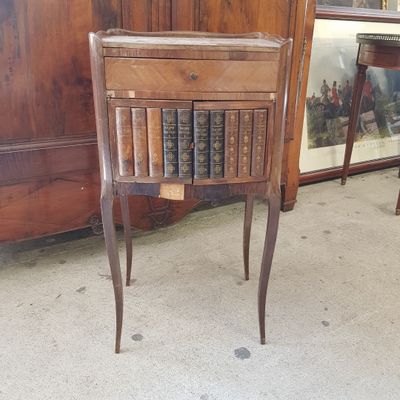 une petite table sur laquelle est posé un livre, devant une armoire
