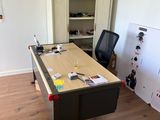 a desk with a chair and a refrigerator in the room