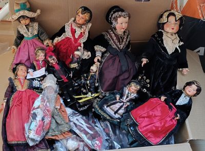 plusieurs poupées dans une boîte posée sur le sol