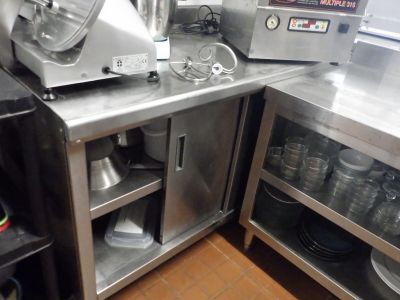 une cuisine avec de nombreux plans de travail en inox
