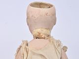 a small doll that is sitting on a white surface