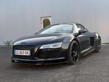 the audi sports car is parked in front of a building