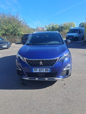 a blue car parked in a parking lot next to other cars