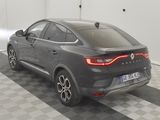 the rear end of a grey car parked in a garage