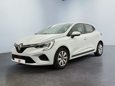 Une voiture blanche est garée dans une pièce au sol noir.