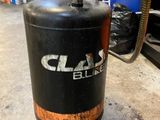 un compresseur d'air noir posé sur un chariot dans un garage