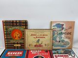 several children ' s books are lined up on a white surface