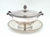 a silver plate with a bowl on it on a saucer