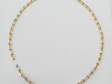 a gold and silver necklace on a white surface