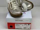 pair of silver shoes on top of a box on a white surface