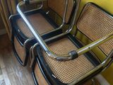 four chairs are lined up against a yellow wall in a room