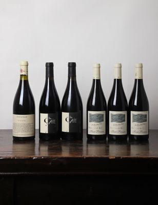 six bouteilles de vin sont alignées sur une table en bois