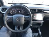 someone is sitting in the driver ' s seat of a car with their feet on the steering wheel