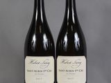 two bottles of wine sitting on top of a table next to each other