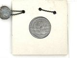 un petit bout de papier auquel est attachée une pièce de monnaie