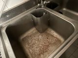 a dirty sink in the kitchen with a faucet in it