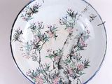 a plate with a painting of a bird and flowers on it