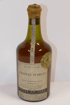 Une vieille bouteille de Château d'Orlay est posée sur une surface blanche.