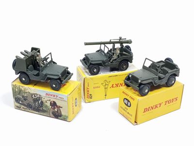 trois véhicules militaires miniatures sont posés sur une boîte