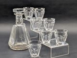 six verres et une carafe posés sur une table