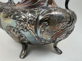 a silver vase that is sitting on a table