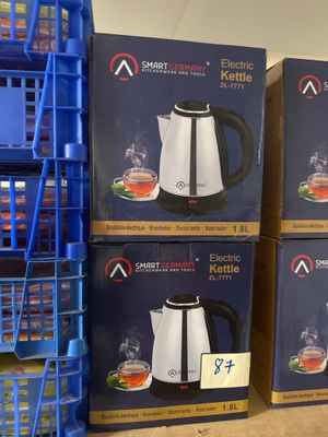 Plusieurs cartons de cafetières sont empilés les uns sur les autres