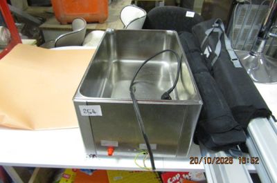 un récipient en métal posé sur une table blanche