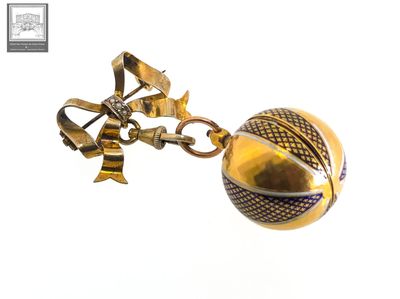 a gold ball with a bow on it hanging from a chain