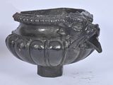 un vase noir orné d'un oiseau sur fond blanc