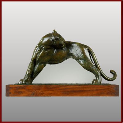 statue d'un lion posée sur un socle en bois et encadrée d'un cadre rouge