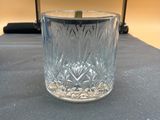 Quelqu'un tient un verre muni d'une anse posé sur une table.
