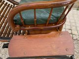 a wooden chair with a green cushion next to a wooden chair with a green cushion