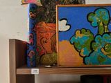 a shelf that has a bunch of art on it