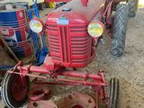 un tracteur rouge garé dans une grange