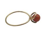 a close up of a ring with a red stone on it